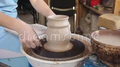 女孩波特在波特`的车轮上雕刻一罐粘土。
